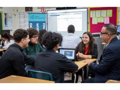 Students discussing with mentors in a classroom setting