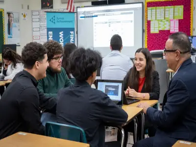 Students discussing with mentors in a classroom setting